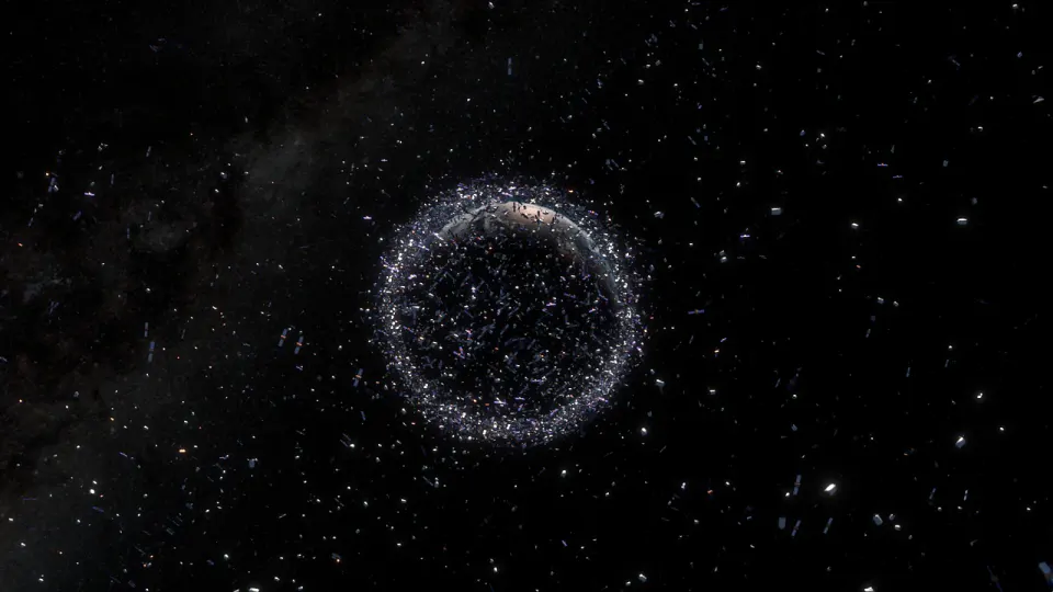 暗い宇宙に浮かぶ地球を、無数の白い点のような人工物が帯状に取り巻いているイメージ画像