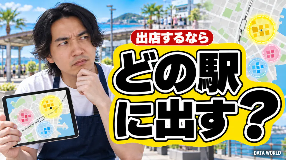 出店するなら、どの駅に出す?。晴れた海沿いの駅前の広場で、紺のエプロンをしたDATA WORLD編集長の小笠原海人が、あごに手を当てて疑うような顔をしている。手には3つの丸が描かれた地図のタブレット。右側に黄色い帯の上に大きく黒い文字で「どの駅に出す?」、その上の赤い札に「出店するなら」。